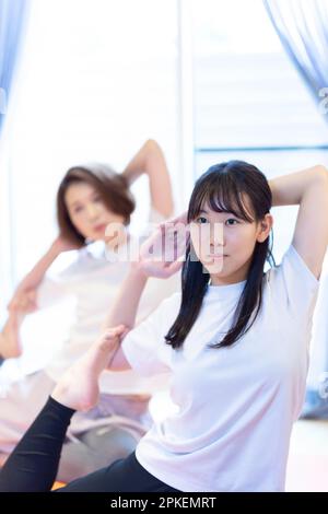 Eltern und Kinder, die zu Hause Yoga machen Stockfoto