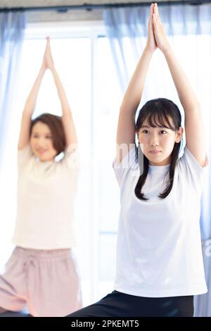 Eltern und Kinder, die zu Hause Yoga machen Stockfoto