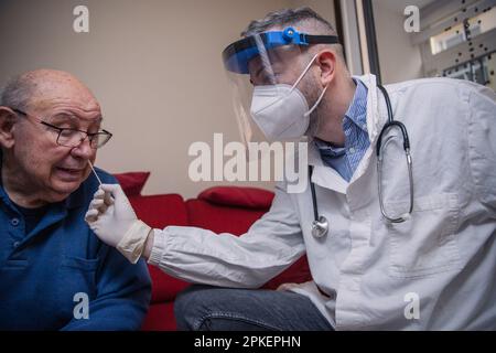 Ein Arzt führt einen Coronavirus-Test mit einem molekularen Abstrich auf der Nase eines älteren Patienten durch. Stockfoto