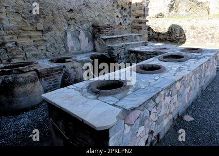 Große Lagerköpfe (Dolium) in einem Lebensmittelgeschäft in Herculaneum, Ruinen in Italien Stockfoto