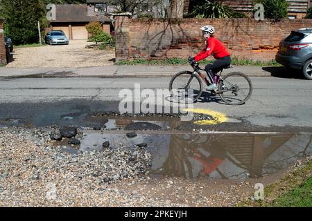 Dorney, Buckinghamshire, Großbritannien. 7. April 2023. Eine der großen und tiefen Schlaglöcher in Dorney Village, Buckinghamshire. Die Village Road ist bei Radfahrern beliebt, die heute ausweichen mussten, um ihr zu entkommen. Auch Autos müssen ausweichen, um dies zu vermeiden, und so besteht die Gefahr eines Frontalzusammenstoßes. Die Straßen in Buckinghamshire gehören zu den schlechtesten in England für Schlaglöcher. Die meisten Schlaglöcher werden nur vorübergehend repariert und kommen daher nach starkem Regen und kaltem Wetter schnell wieder. Kredit: Maureen McLean/Alamy Live News Stockfoto