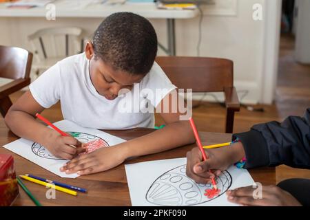 Detroit, Michigan – Kinder malen ostereier in einem Kunstprojekt in einem brillanten Zentrum von Detroit im Viertel Morningside. Brillante Detr Stockfoto