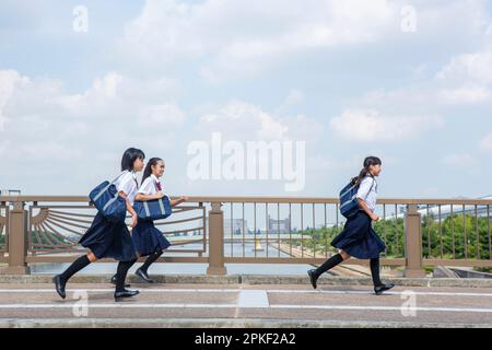 Schüler der Junior High School laufen auf einer Brücke Stockfoto