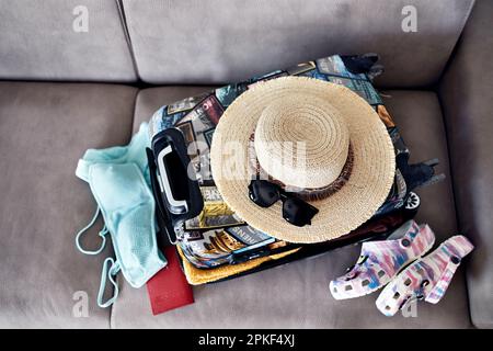 Gepäck und Koffer packen für Urlaub auf dem Bett, schließen Stockfoto