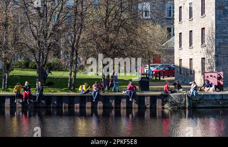 Leith, Edinburgh, Schottland, Großbritannien, 7. April 2023. Wetter in Großbritannien: Sonnenschein auf Leith. Das herrliche sonnige Wetter am Karfreitag bringt die Menschen dazu, am Ufer des Wassers von Leith in der Sonne zu sitzen. Kredit: Sally Anderson/Alamy Live News Stockfoto