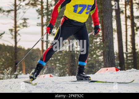 Nahaufnahme männlicher Sportler beim Skilanglauf, auf den Beinen und auf dem Anhänger, um das Ergebnis zu kontrollieren Stockfoto