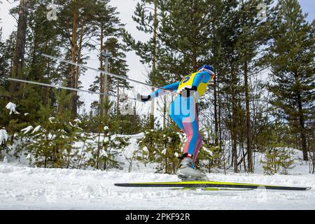 Männlicher Sportler, der Skilanglauf im Skating-Stil läuft, Wintersportwettbewerb Stockfoto