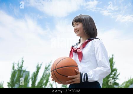 Junior High School Schülerin mit einem Basketball Stockfoto