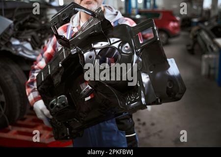 Große schwarze Details des Autos in den Händen des Menschen Stockfoto