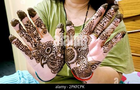 Ein wunderschönes Kunstwerk, das auf der Hand einer indischen Braut mit Kräuter heena in nassem Zustand gezeichnet wurde. Stockfoto