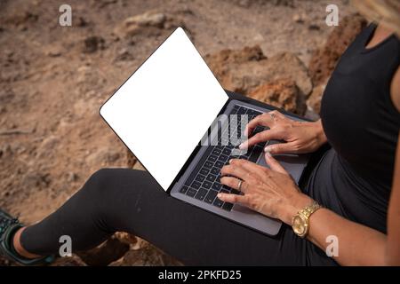 Nahaufnahme eines leeren Bildschirms eines Laptops, der von einem Wanderer verwendet wird, mit Modell Stockfoto