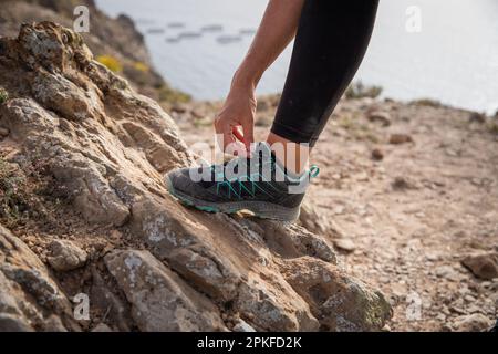 Eine Wanderer bindet ihre Schuhe, Nahaufnahme des Fußes. Stockfoto