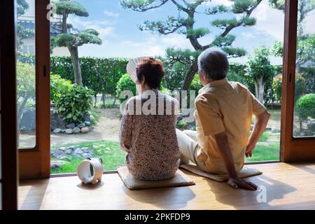 Ein älteres Paar, das auf der Veranda sitzt Stockfoto