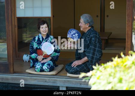 Das alte Paar sitzt auf der Veranda Stockfoto