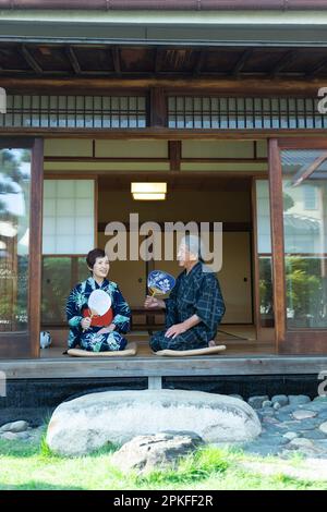 Das alte Paar sitzt auf der Veranda Stockfoto