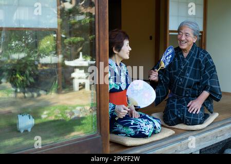Das alte Paar sitzt auf der Veranda Stockfoto