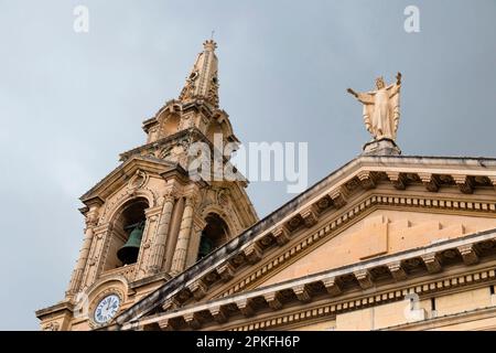 Floriana, Malta - 12. November 2022: Statue von Christus dem König auf dem Pediment und Glockenturm der Gemeinde St. Publius Stockfoto