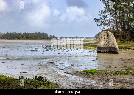 Menhir de Penglaouic bei Ebbe an der Flussmündung der Pont l'Abbe mit Île-Tudy im Hintergrund, Bretagne, Frankreich Stockfoto