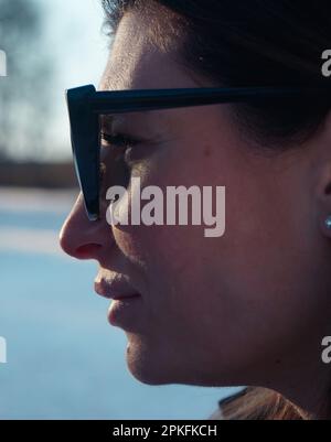 Nahaufnahme einer Frau, die im Winter eine Sonnenbrille trägt Stockfoto