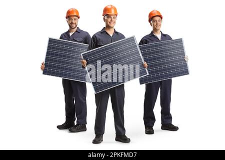 Fabrikarbeiter in Uniformen, die Solarpaneele auf weißem Hintergrund isoliert halten Stockfoto