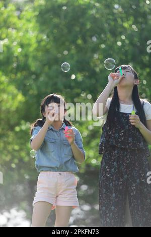 Familie spielen mit Seifenblasen Stockfoto