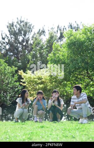 Familie spielen mit Seifenblasen Stockfoto