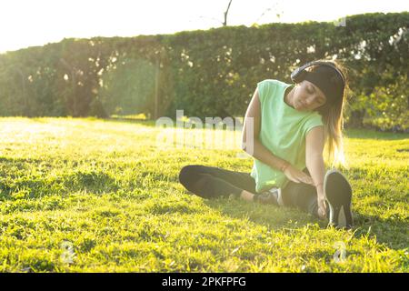 Teenager, die im Park Stretching-Übungen macht Stockfoto