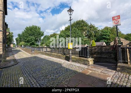 Viktorianische Kopfsteinpflasterstraße am Bahnhof Saltaire, Saltaire, Yorkshire Dales; Ausgangspunkt des Fernweges Dales High Way. Stockfoto