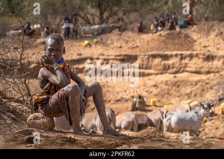 Kenia. 18. Februar 2023. Ein Kind aus dem Turkana-Stamm, das auf seine Familie wartet, nahe am Brunnen der Klimawandel verursacht in Ostafrika die schlimmste Dürre in seiner Geschichte: Es hat in dieser Region seit mehr als drei Jahren nicht mehr geregnet, und mehr als 36 Millionen Menschen sind mit den verheerenden Folgen einer Welle konfrontiert, die laut Prognosen nicht in absehbarer Zeit enden wird. In Turkana, nördlich von Kenia, kämpfen die Menschen, um diese schreckliche Dürre zu überleben. Kredit: SOPA Images Limited/Alamy Live News Stockfoto