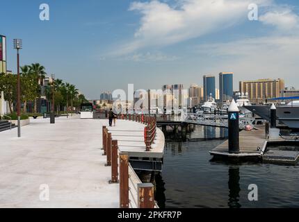 Blick auf den Creek in Richtung Deira mit großen Booten, die an der Promenade Al Seef in Dubai, Vereinigte Arabische Emirate, angelegt sind Stockfoto