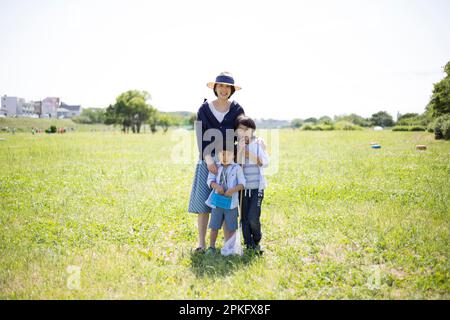 Geschwister und Mutter mit Insektennetzen auf der Wiese Stockfoto