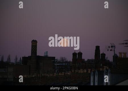 Newcastle Upon Tyne, 7. April 2023, Pink Moon - Paschal Vollmond über den Dächern von Newcastle Upon Tyne, der Mond ist nach einer heißen rosa Wildblume namens Phlox subulata benannt, der Paschal Vollmond ist der erste Vollmond nach dem Frühlings-Tagundnachtgleiche. Der Vollmond von Paschal ist von Bedeutung, da er bestimmt, welches Osterdatum jedes Jahr fällt, Credit:DEW/Alamy Live News Stockfoto