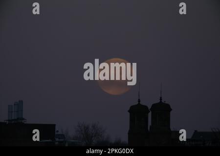 Newcastle Upon Tyne, 7. April 2023, Pink Moon - Paschal Vollmond über den Dächern von Newcastle Upon Tyne, der Mond ist nach einer heißen rosa Wildblume namens Phlox subulata benannt, der Paschal Vollmond ist der erste Vollmond nach dem Frühlings-Tagundnachtgleiche. Der Vollmond von Paschal ist von Bedeutung, da er bestimmt, welches Osterdatum jedes Jahr fällt, Credit:DEW/Alamy Live News Stockfoto