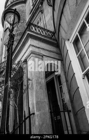 Abstraktes Bild der Bath-Architektur. Georgianische Straßenlampe, Portico, Balkon und Fenster. Bath, England. Badestein. Schwarzweißfoto. Stockfoto