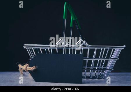 Warenkorb und leeres Preisschild für die Beschriftung. Der Preis des Produkts. Verkauf im Supermarkt. Stockfoto