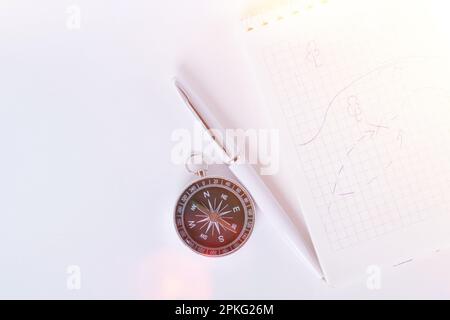 Reisenotizen. Ein sauberes Notizbuch mit Stift zum Schreiben eines Kompasses und einer Karte. Das Konzept des Reisens. Stockfoto