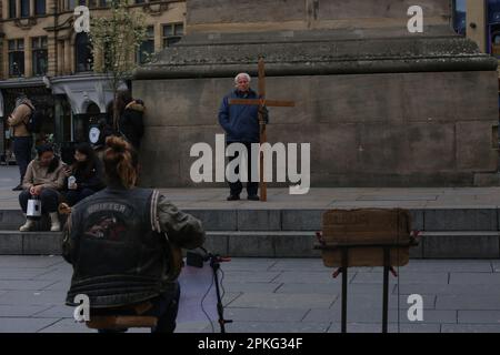 Newcastle upon Tyne, Vereinigtes Königreich, 7. April 2023. Karfreitag in Newcastle, Mann mit Kreuz am Grey's Monument und Chippy Queues im Starbeck Avenue Fish Shop für traditionellen Karfreitagsfisch und Chips, Credit:DEW/Alamy Live News Stockfoto