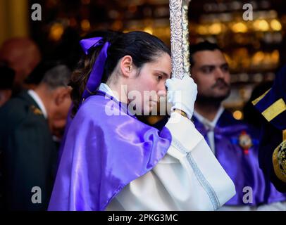 Eine nachdenkliche junge Frau, die während der Heiligen Woche gesehen wurde. Die Bruderschaft Jesús 'El Pobre' und Dulce nombre kehren nach drei Jahren in die Straßen von Madrid zurück. Der Guide Cross hat die Prozession begonnen. In diesem Jahr wird der Trommelabschnitt der Jesús "El Pobre" Musical Group, begleitet von dem Querführungsband, wiedergefunden. Nach den Musikern hat der Körper der Nazarenen, die Abzeichen und die Eskorte begonnen. Der Hafen von Jesús „El Pobre“ verfügt über 48 Oranderos und 15 Reservate, geführt von Carlos Blanco und Ángel Benito. Seine musikalische Begleitung hat mit dieser Bruderschaft gespielt Stockfoto