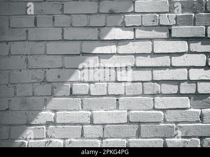 Von der Sonne geküsste weiße Backsteinmauer: Ein einzigartiger Hintergrund für Ihre nächste Fotosession Stockfoto