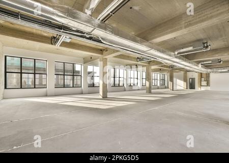 Ein leerer Bürobereich mit vielen Fenstern und Licht, das von der Sonne durch das Panoramafenster hereinkommt Stockfoto