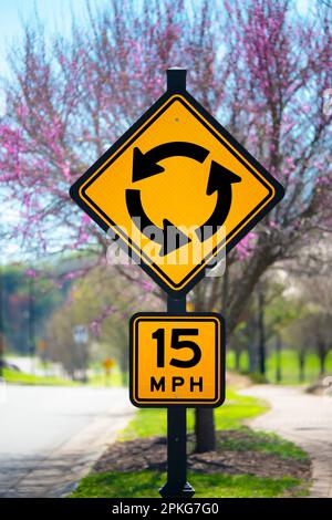 Vertikales Bild eines Kreisschilds vor einem aufkeimenden Baum im Frühling. Stockfoto