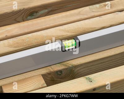 Wasserwaage die Wasserwaage einer Holzbohle prüfen. Nahaufnahme. Stockfoto