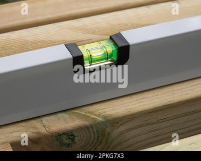 Wasserwaage die Wasserwaage einer Holzbohle prüfen. Nahaufnahme. Stockfoto