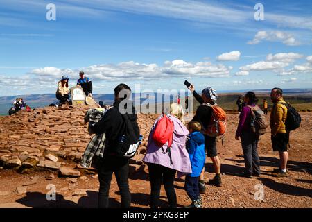 UK Weather: Karfreitag-Feiertag, 7. April 2023. Brecon Beacons National Park, Südwales. Wanderer lassen sich auf dem Gipfel des Pen y Fan im Brecon Beacons National Park fotografieren. Pen y Fan (886m / 2.907ft) ist der höchste Gipfel im Brecon Beacons National Park und im Süden Großbritanniens und ein beliebtes Wanderziel. Das schöne, sonnige Wetter bedeutete, dass viele Leute die Reise in den Park für den heutigen Feiertag machten. Stockfoto