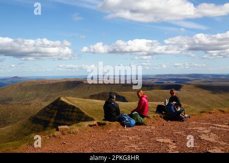 UK Weather: Karfreitag-Feiertag, 7. April 2023. Brecon Beacons National Park, Südwales. Wanderer genießen die Aussicht vom Gipfel des Pen y Fan im Brecon Beacons National Park. Der Gipfel in der Mitte ist Cribyn, der nächste Gipfel entlang des Kammes. Das schöne, sonnige Wetter bedeutete, dass viele Leute die Reise in den Park für den heutigen Feiertag machten. Stockfoto