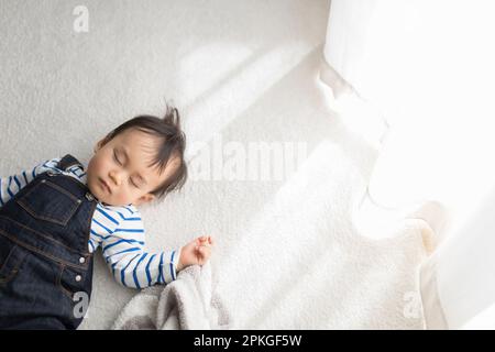 Baby macht ein Nickerchen im Wohnzimmer Stockfoto