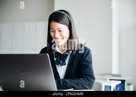 Highschool-Mädchen bedienen einen Computer in einem Klassenzimmer Stockfoto