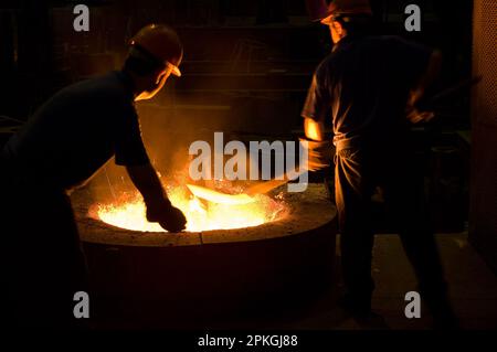 Eisen-Stahl ist in einem Hochtemperaturofen geschmolzen. Der Prozess, der unter sehr schwierigen Bedingungen durchgeführt wird, ist auch Schauplatz visueller Feinheiten Stockfoto