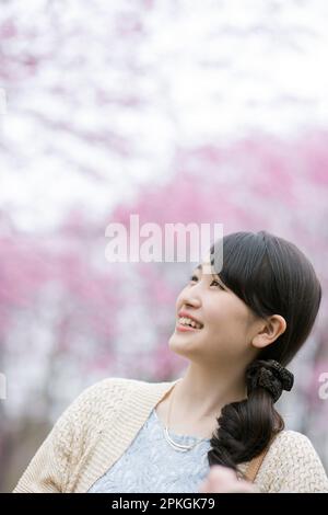 Frau Suchen im Cherry Blossoms Stockfoto