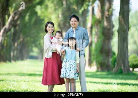 Die Familie lächelt auf einer Reihe von Pappelbäumen Stockfoto